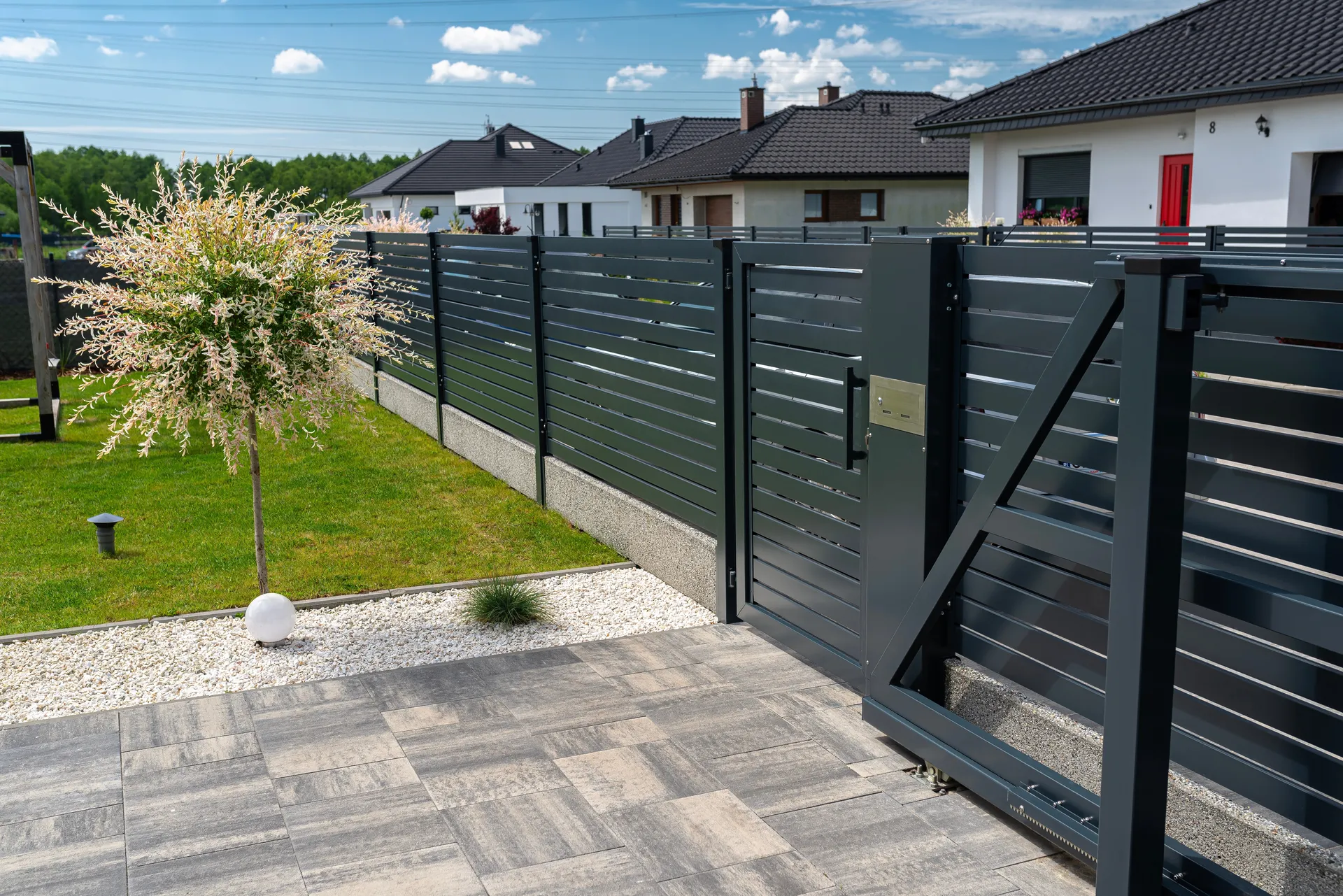 Dark gray aluminum slat fence with pedestrian gate
