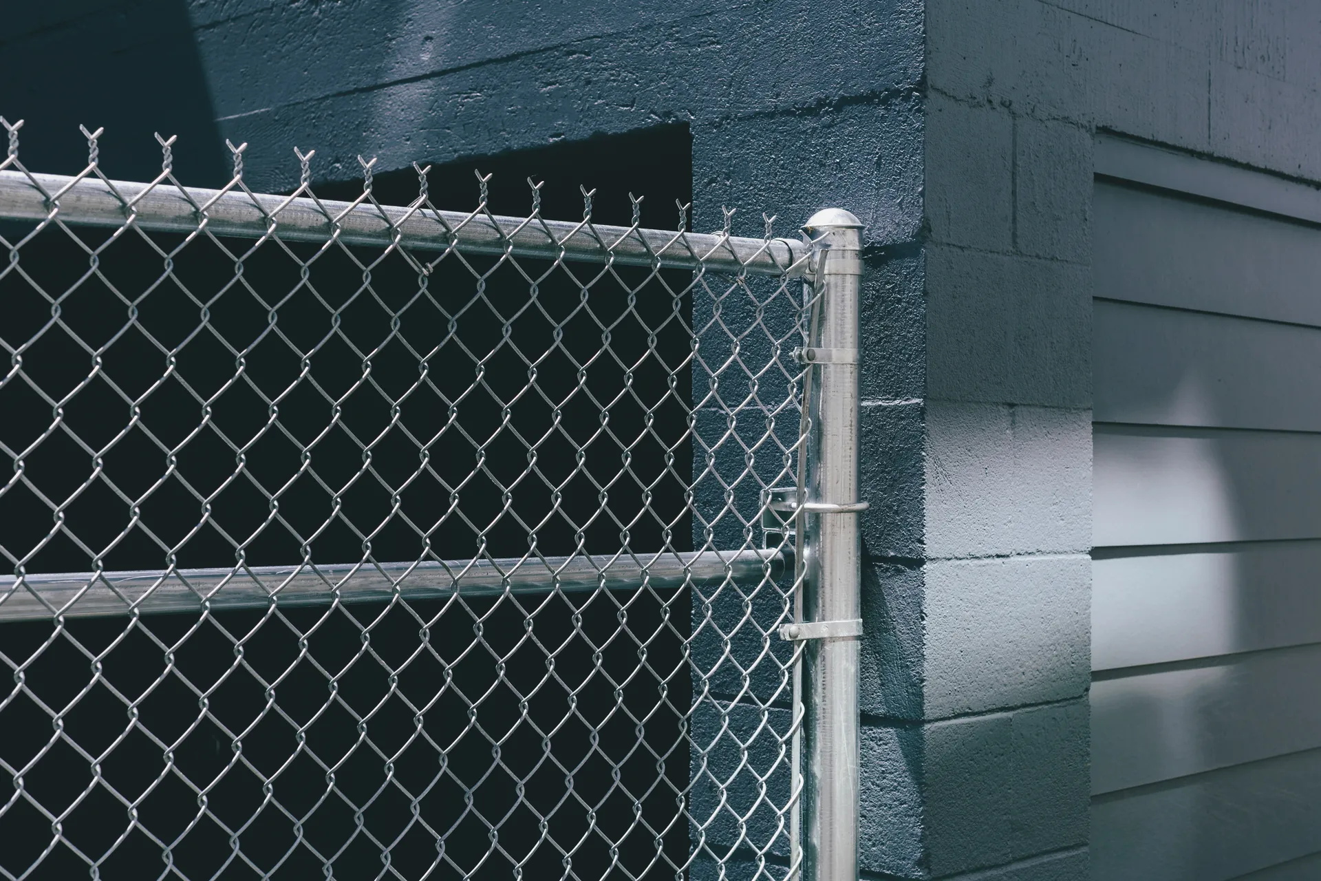 Close-up of galvanized chain link fence showing diamond mesh pattern