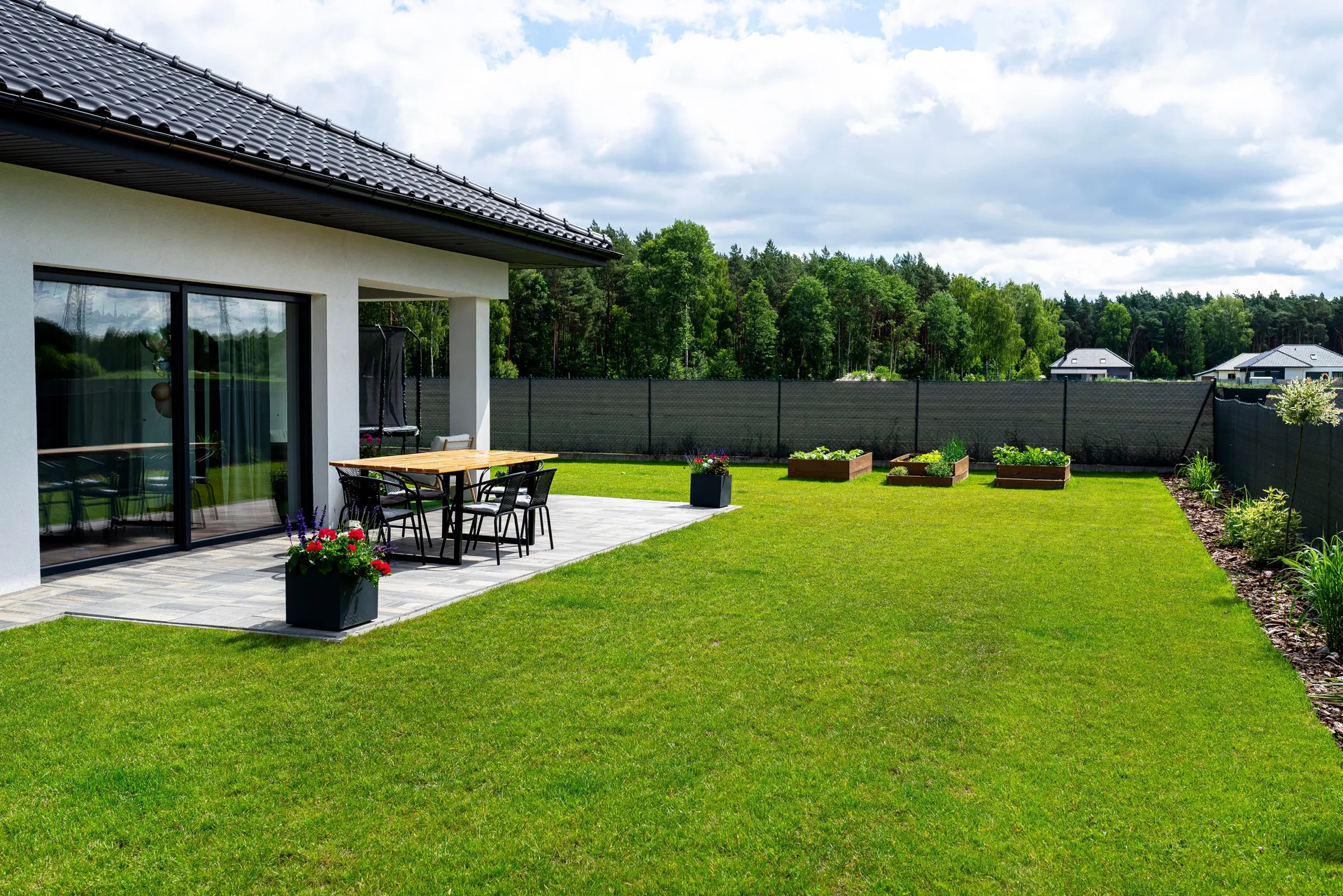 Modern backyard patio with dark privacy fence