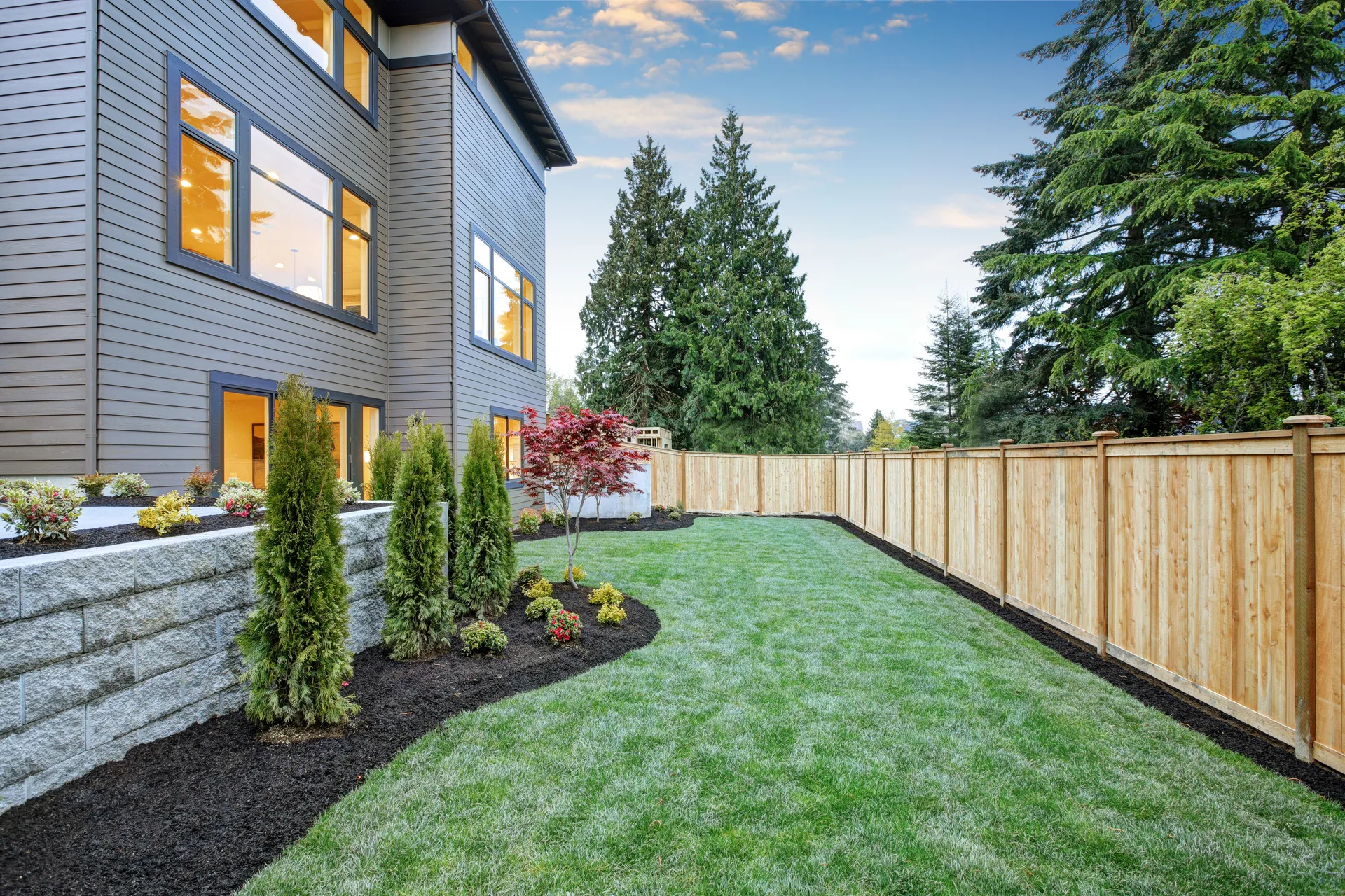 New cedar fence at modern home with backyard landscaping