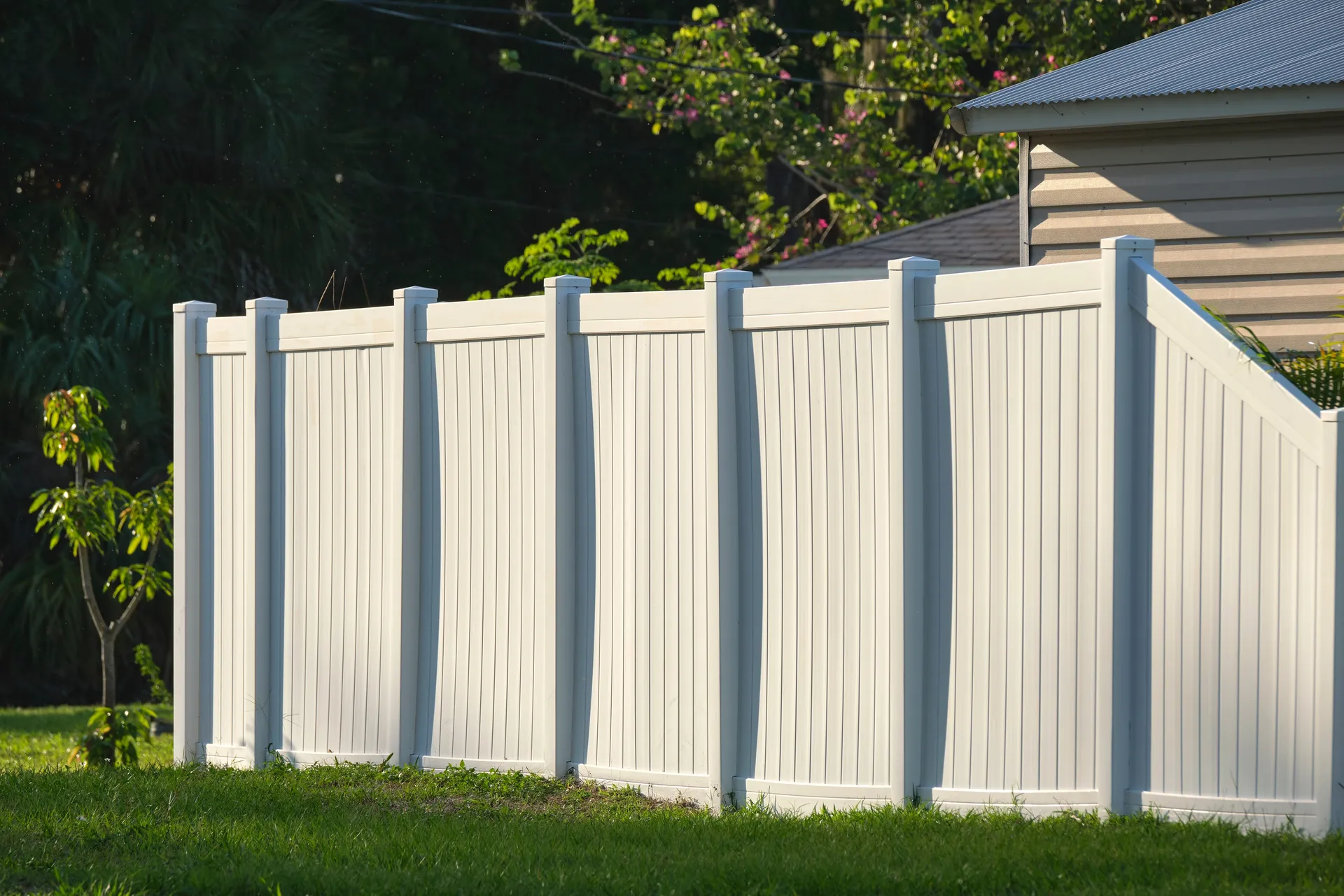 White vinyl privacy fence in a backyard setting