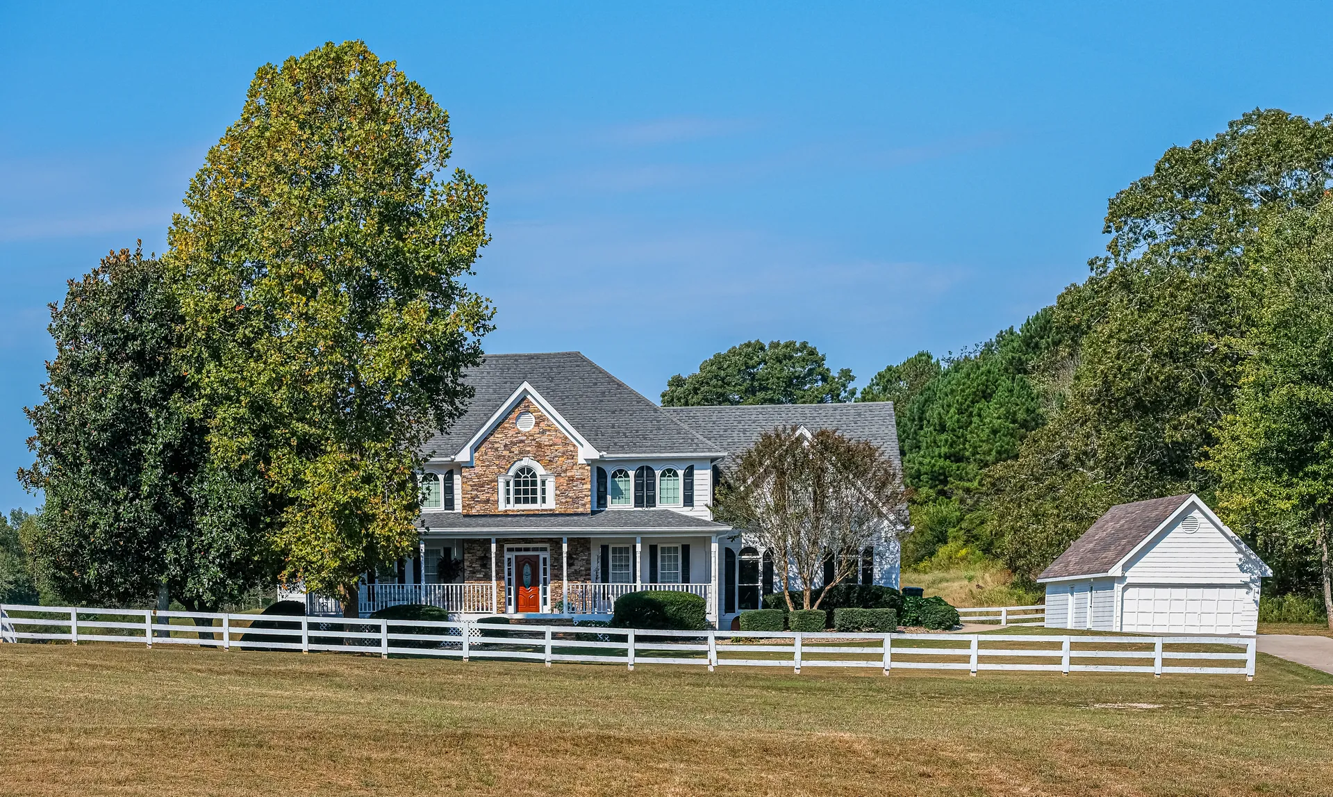 White vinyl ranch rail fence at a country home